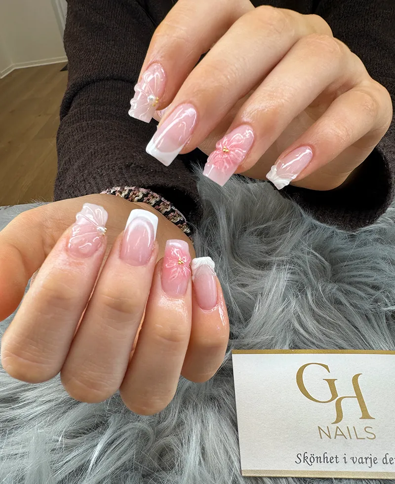 Avancerad 3D-nagelkonst med blommor och fransk manikyr på fyrkantiga naglar hos GH Nails i Örebro.