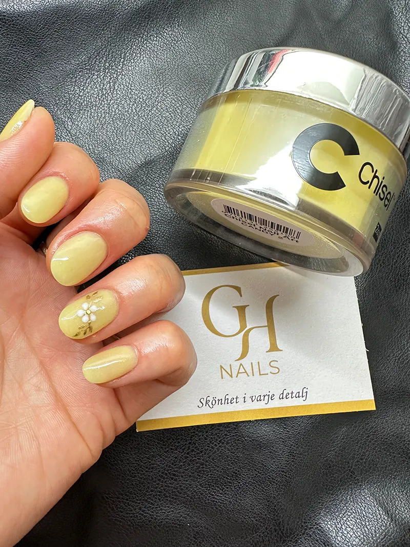 Gula dip powder-naglar med en liten blomdetalj utförda på GH Nails i Örebro.